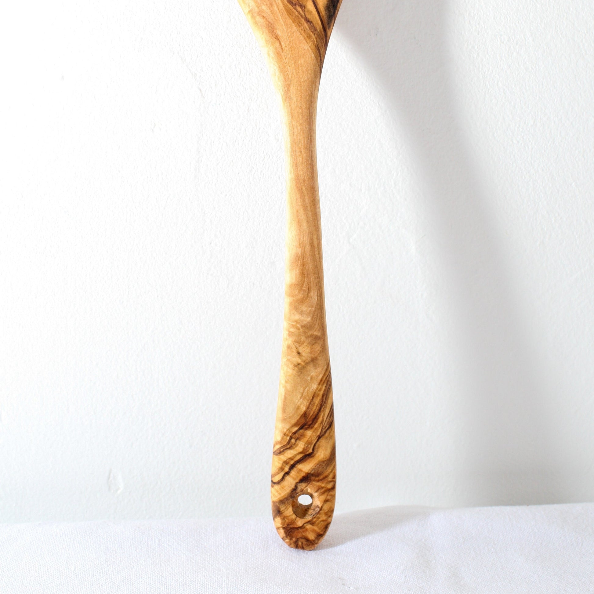 the handle of an olive wood kitchen spoon